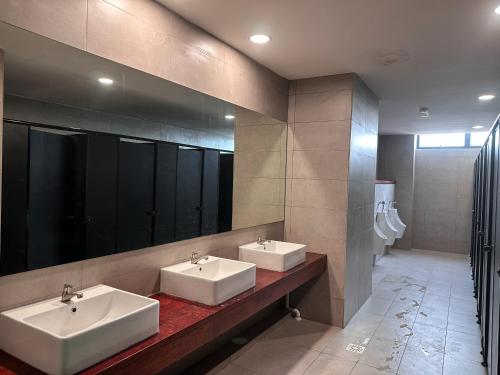 a bathroom with two sinks and a mirror at Disneyland Theme DFB homestay 03 Gala City Armadale Residence in Kuching