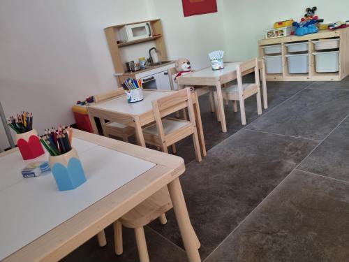 a room with two tables and chairs and a kitchen at Camping Essenza Alpina in Folgaria