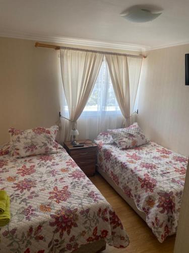 1 dormitorio con 2 camas y ventana en Departamento 9 Avenida argentina 2272,Antofagasta en Antofagasta