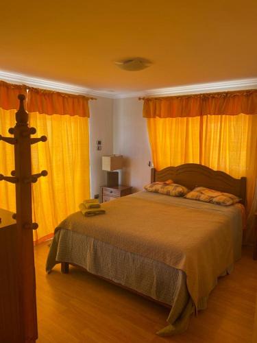 1 dormitorio con 1 cama grande y cortinas amarillas en Departamento 9 Avenida argentina 2272,Antofagasta en Antofagasta