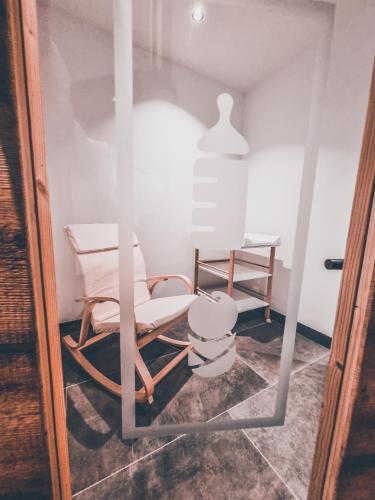 a room with a chair and a table at Camping Essenza Alpina in Folgaria