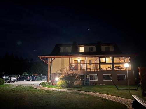 ein Haus in der Nacht mit eingeschaltetem Licht in der Unterkunft Agroturystyka Pokoje U Sołtysa in Goniądz