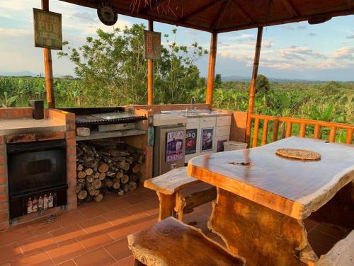 a patio with a table and a fireplace on a deck at Finca Monte del Sol in Quimbaya