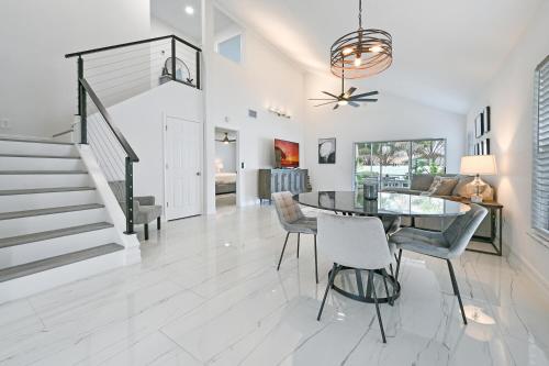 a dining room and living room with a glass table and chairs at Spacious+Cozy Home, near the beach, heated pool. in Naples