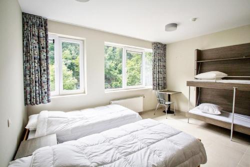 Duas camas num quarto com janelas e um piano em J-Club De Knapzak / La Besace em Bohan