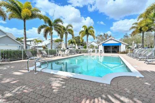 a swimming pool with chairs and palm trees at Spacious+Cozy Home, near the beach, heated pool. in Naples