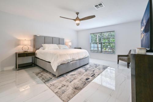 a bedroom with a bed and a ceiling fan at Spacious+Cozy Home, near the beach, heated pool. in Naples