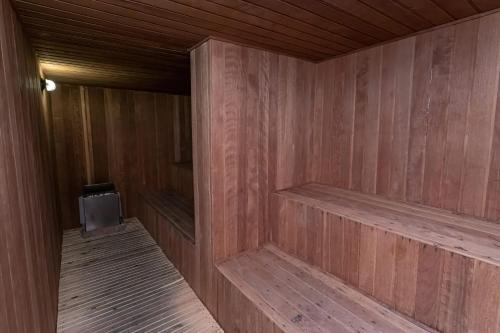 a sauna with wooden walls and a tv in it at Flat incrível e acessível ao lado da Paulista in São Paulo