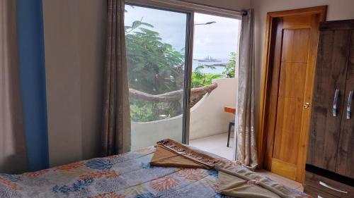 a bedroom with a bed and a large glass door at Hostal Cabañas Don Jorge in Puerto Baquerizo Moreno
