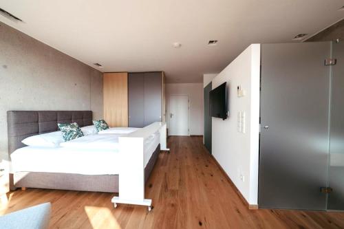 a bedroom with a white bed and a television at Weinlandzauber An der Lage in Spielfeld