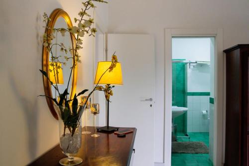 a vase with flowers on a table next to a lamp at B&B Massico Apartments in Sant'Agnello