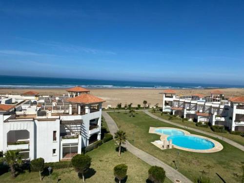 an aerial view of a resort with a pool and the beach at Appartement de vacances BERALMAR CHEZ HOUDA in Asilah