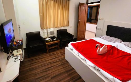 una habitación de hotel con una cama con un cisne en ella en Hotel Royal Brooks, en Chandīgarh