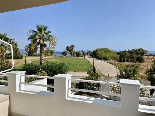 a white fence with a view of a park at Maia beach house in Rafina