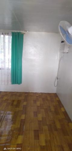 Cette chambre dispose d'un rideau vert et de parquet. dans l'établissement beach Housenice view beach, à Mananda