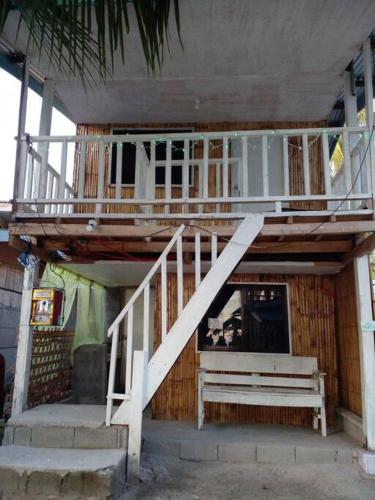 um edifício com uma varanda e uma escadaria em beach Housenice view beach em Mananda