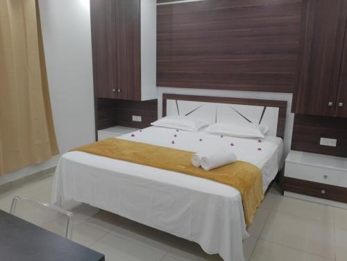 1 dormitorio con 1 cama grande con sábanas y almohadas blancas en Le Lointain, en Mtsamboro