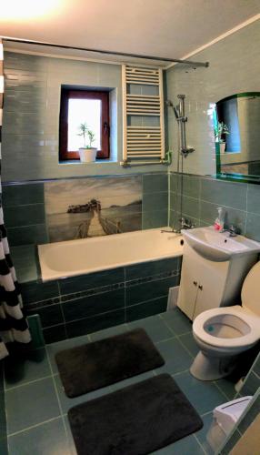 a bathroom with a tub and a toilet and a sink at Pensiunea Panorama in Băile Tuşnad
