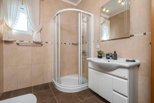 a bathroom with a shower and a sink at Casa do Palheiro Ribeirinho in Porto Moniz