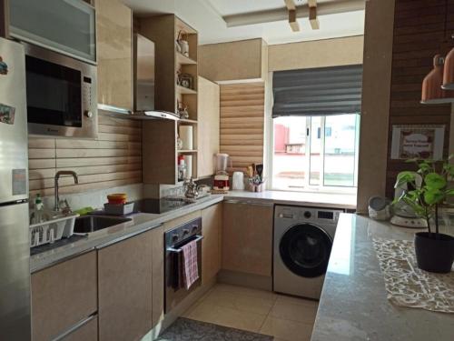 a kitchen with a sink and a washing machine at Adam's home in Rabat