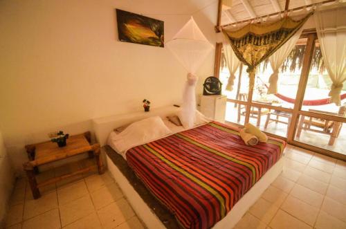 1 dormitorio con 1 cama en una habitación con ventana en La Casa de Sebas - Pool Beach Hotel Mancora, en Máncora