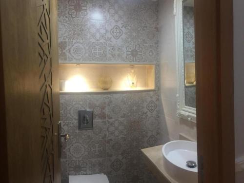 La salle de bains est pourvue d'un lavabo, de toilettes et d'un miroir. dans l'établissement Adam's home, à Rabat