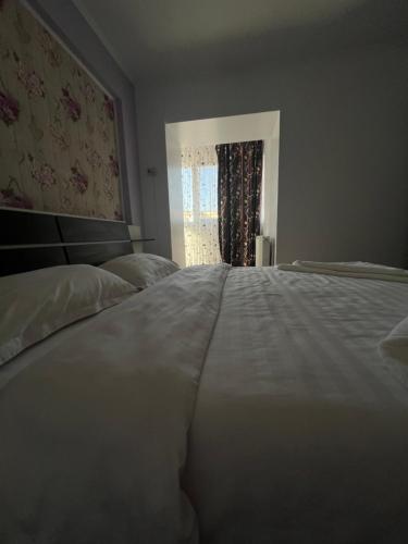 a large white bed in a bedroom with a window at Apartament Wide View in Buzău