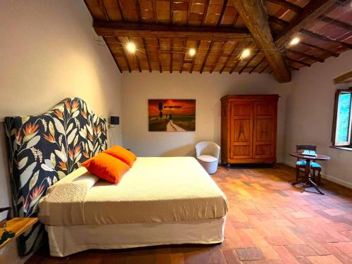 a bedroom with a bed and a chair and a desk at La Corte del Chianti Classico in Gaiole in Chianti