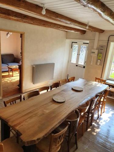 une grande table en bois et des chaises dans une pièce dans l'établissement La maison de René, gîte cœur d'Auvergne, à Fontannes