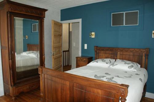une chambre avec un lit et un mur bleu dans l'établissement La maison de René, gîte cœur d'Auvergne, à Fontannes