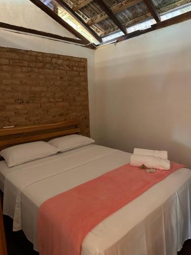 ein Schlafzimmer mit einem Bett mit zwei Handtüchern darauf in der Unterkunft Chácara da Tuia in Estancia do Castello