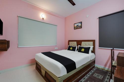1 dormitorio con cama grande y pantalla grande en Super Collection O Veritas Grand, en Bangalore