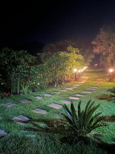 a walkway at night with lights on the grass at Chácara da Tuia in Estancia do Castello