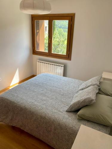 a bedroom with a bed and a window at Apartamento Balcón del Ésera in Villanova