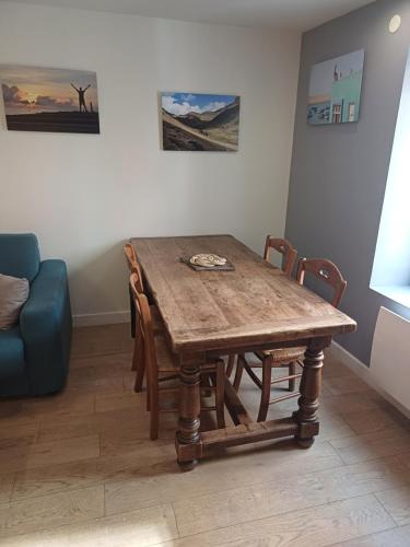 a wooden dining room table with chairs and a couch at Le grenier à sel, Chaleureux 2 Chambres-Centre-Gare in Reims