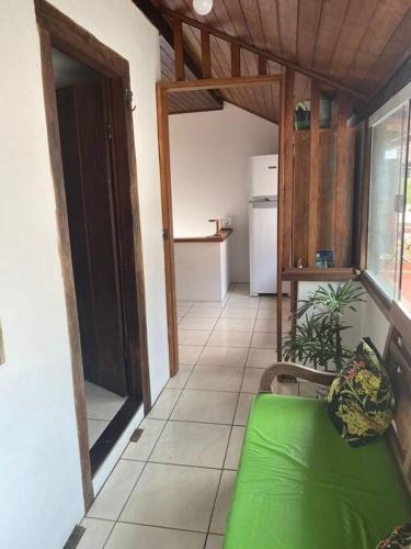 ein Wohnzimmer mit einem grünen Sofa und einer Küche in der Unterkunft Casa Beira Mar, Paraty-RJ in Paraty
