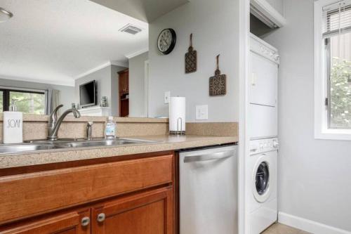 a kitchen with a sink and a dishwasher at Modern Golfview Condo near the Grand Traverse Bay in Williamsburg