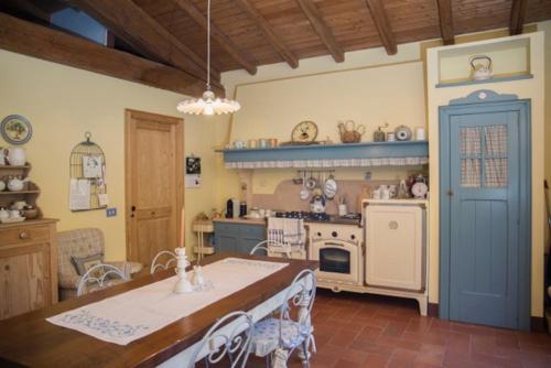 a kitchen with a stove and a table in a room at Casetta dei lagoni in Arona