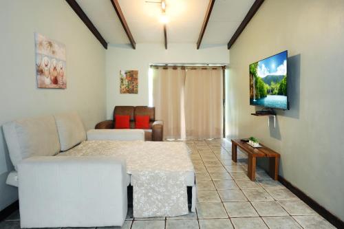 a living room with a bed and a couch at Wide Mouth Frog Quepos in Manuel Antonio