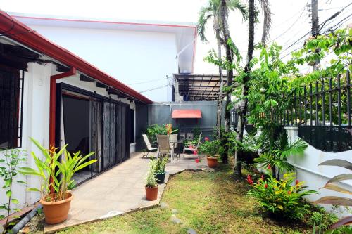 a courtyard in a house with plants at Wide Mouth Frog Quepos in Manuel Antonio