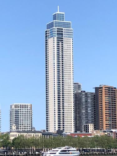 a large tall building with a boat in a city at Imagine My B&B in Rotterdam