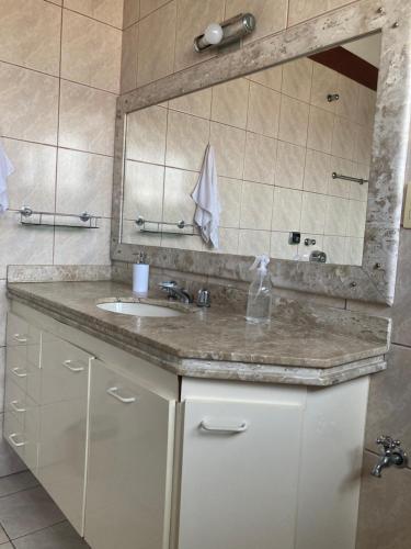 La salle de bains est pourvue d'un lavabo et d'un miroir. dans l'établissement Casa em Aparecida, à Aparecida