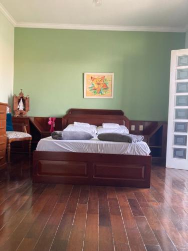 - une chambre avec un grand lit et une tête de lit en bois dans l'établissement Casa em Aparecida, à Aparecida