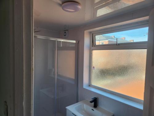 a bathroom with a sink and a glass window at Long Stay, Contractors, Stags & Hens in Elswick