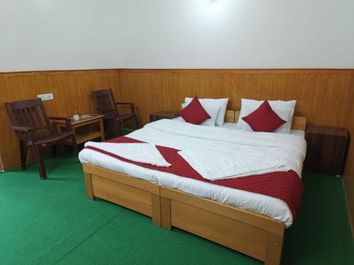 a bedroom with a bed with red and white pillows at Enchanting Tawang in Tawang