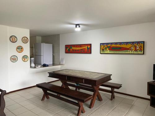 a dining room with a table and a bench at Casa no Paraíso dos Carneiros em Tamandaré in Tamandaré
