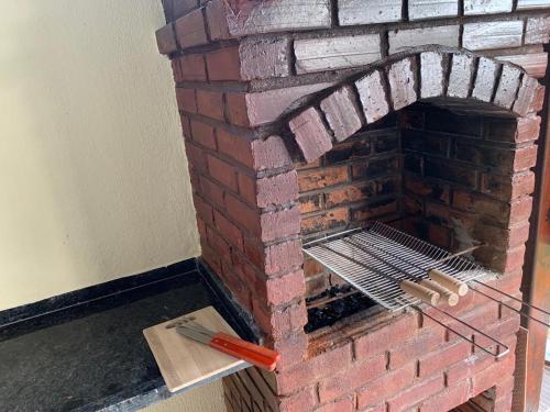 un horno de ladrillo con una parrilla en él en Casa no Paraíso dos Carneiros em Tamandaré, en Tamandaré