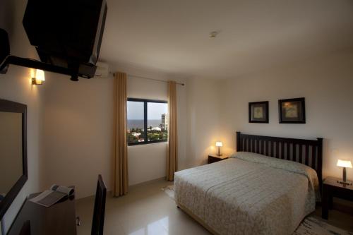 a bedroom with a bed and a large window at Vip Executive Suites Maputo in Maputo
