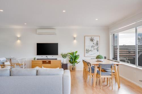 a living room with a couch and a table with chairs at Becker Bliss - Ocean views, 5 bedrooms, sleeps 12 in Forster