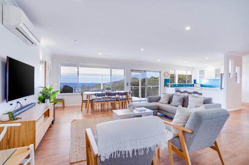 ein Wohnzimmer mit einem Sofa und einem TV in der Unterkunft Becker Bliss - Ocean views, 5 bedrooms, sleeps 12 in Forster